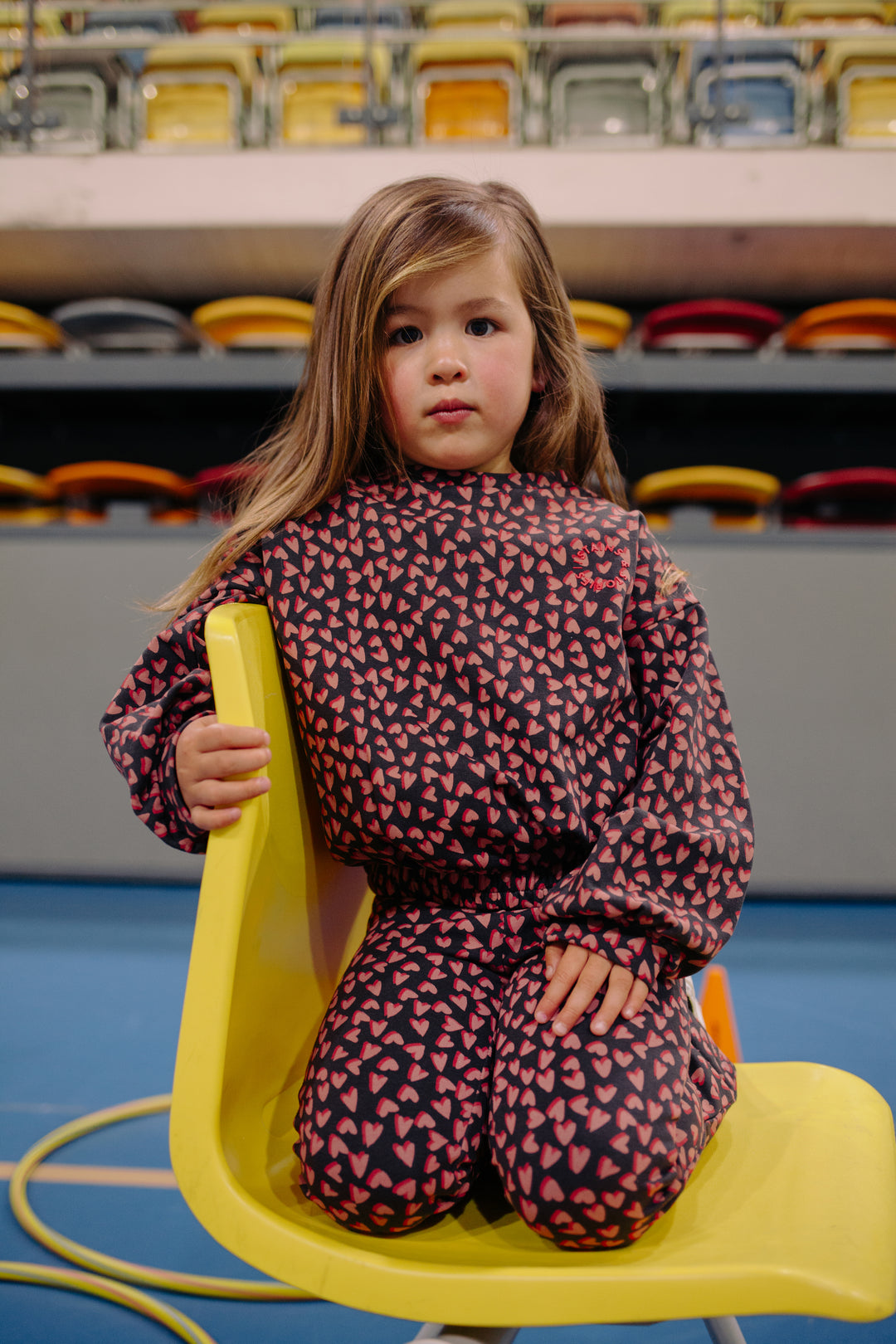 Stains & Stories Hearts All Over Sweatshirt and pants model seat