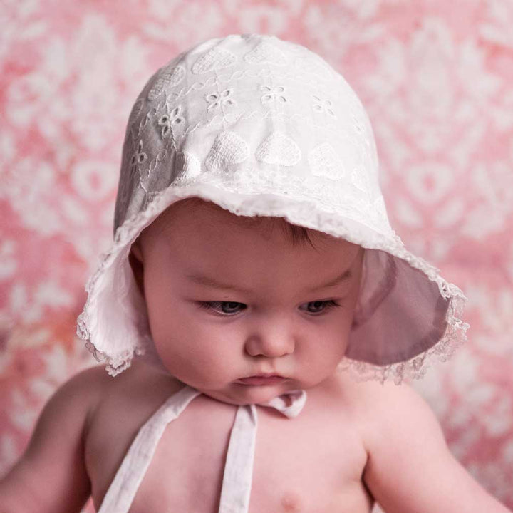 Huggalugs Heart Eyelet Baby Bonnet model front