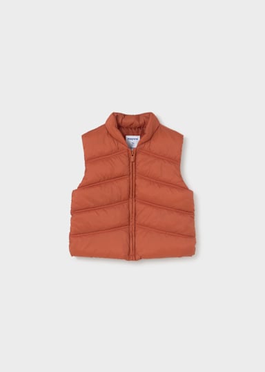 A sleeveless quilted puffer vest in a muted terracotta orange color, featuring a full-zip front and a stand-up collar, shown flat against a light gray background.